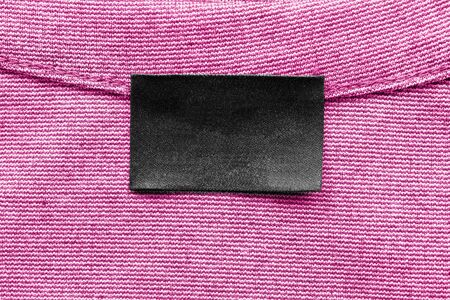 Black blank clothes label on pink clothの写真素材