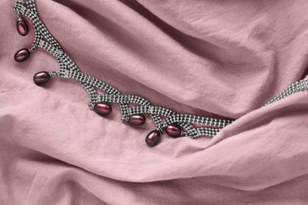 Pearl necklace on pink draped linen as a backgroundの写真素材