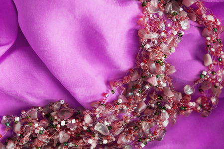 Pink glass beads on magenta silk as a backgroundの写真素材