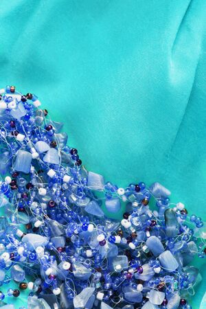 Blue crystal beads on silk as a backgroundの写真素材