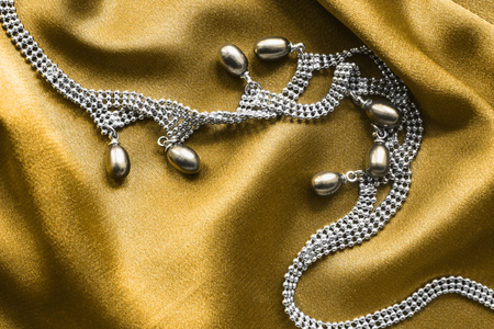 Pearl necklace on golden draped silk as a backgroundの写真素材