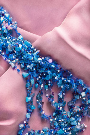 Strings of blue beads on blush silk as a backgroundの写真素材