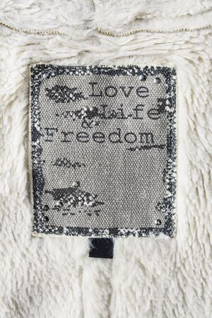 Clothes label on white fur as a backgroundの写真素材