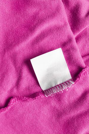 Blank white label on pink cloth as a backgroundの写真素材