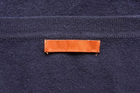 Blank orange label on violet knitwear as a backgroundの写真素材