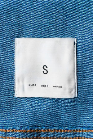 White clothes label on blue denim as a backgroundの写真素材