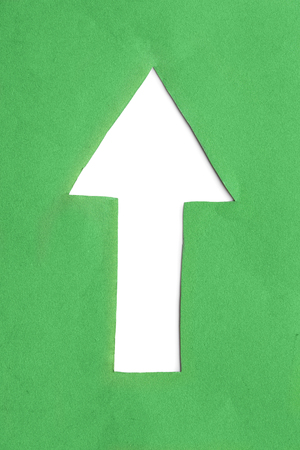 Blank white up arrow cut in green paperの写真素材