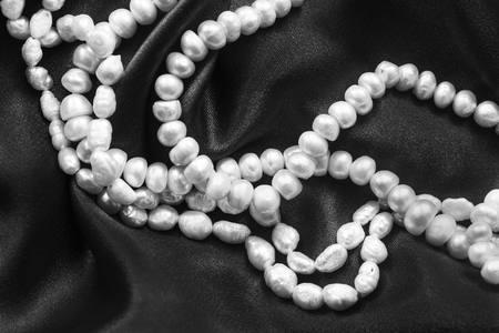 Pearl necklace on draped black silk as a backgroundの写真素材