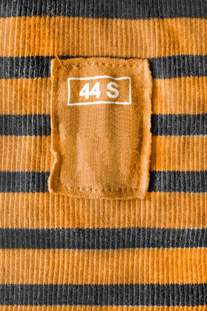 Yellow clothes label on striped knitted cloth