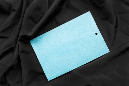 Blank blue paper label on black silk as a backgroundの写真素材