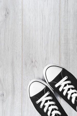 Pair of black gumshoes on white wooden floorの写真素材