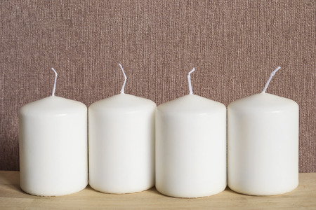Group of white candles on wooden desk closeupの写真素材