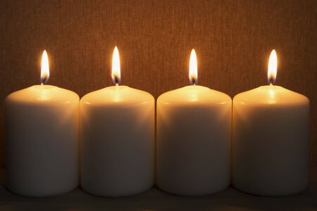 Group of four burning candles closeup as a backgroundの写真素材