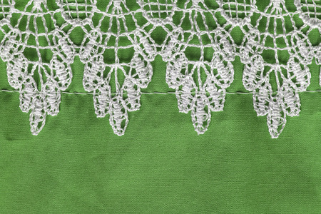 Vintage white lace on green cotton as a backgroundの写真素材