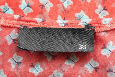 Blank black clothes label on red chiffonの写真素材
