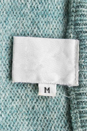 Blank white clothes label on knitted backgroundの写真素材