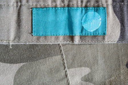 Blank blue clothes label on khaki as a background