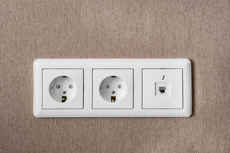Power and telephone sockets on brown wall as a backgroundの写真素材