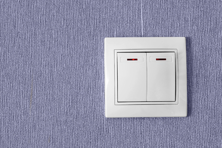 White domestic electric switch on purple wall as a backgroundの写真素材