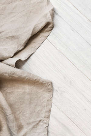 Folded beige linen on white wooden floor as a backgroundの写真素材