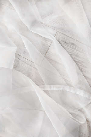 White draped transparent tulle on wooden floor as a backgroundの写真素材