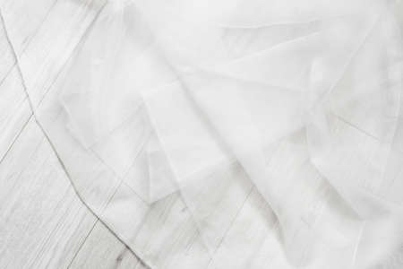 White folded tulle on white wooden backgroundの写真素材