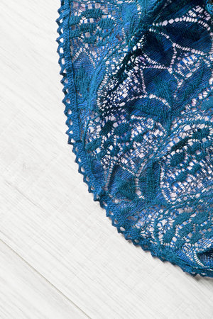 Blue lace on white wooden background closeup