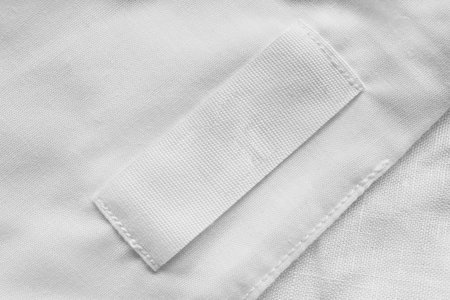 White blank clothes label on white linen as a backgroundの写真素材