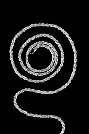 Silver chain in the shape of helix on black backgroundの写真素材