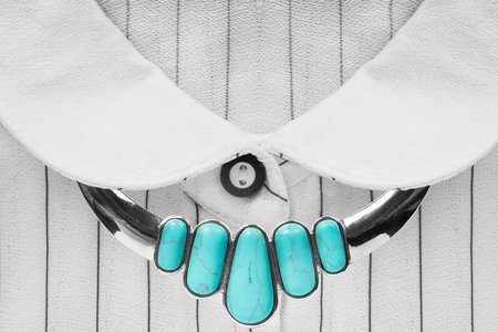 Turquoise necklace on white silk blouse closeup