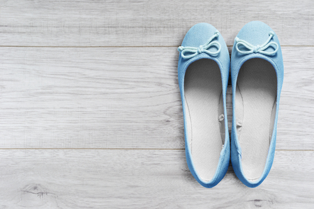 Pair of beautiful blue flat shoes on wooden floorの写真素材
