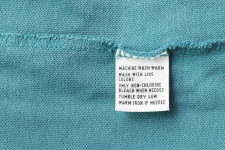 Washing instructions clothes label on blue cloth as a backgroundの写真素材