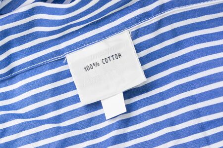 Fabric composition label on striped blue cotton as a backgroundの写真素材