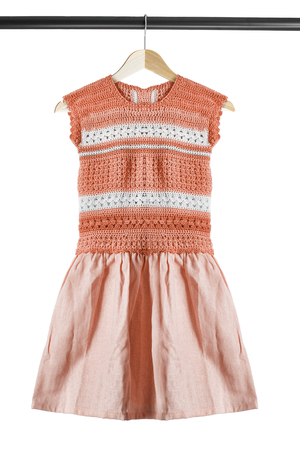 Knitted dress on wooden clothes rack isolated over whiteの写真素材