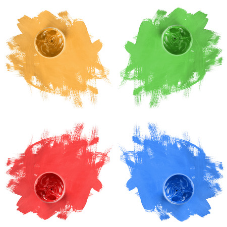 Jars of colorful paint and brush strokes isolated over whiteの写真素材