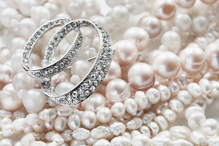 Diamond brooch and strings of pearl closeup as a backgroundの写真素材