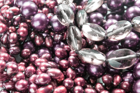 Pink purple and transparent beads closeup as a background