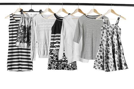 Black and white clothes on clothes racks isolated over whiteの写真素材