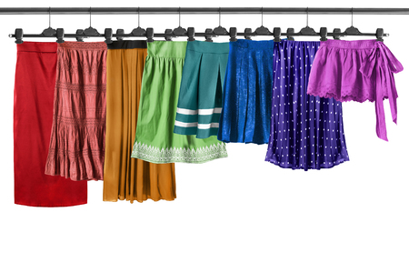 Set of colorful skirts on clothes racks isolated over whiteの写真素材