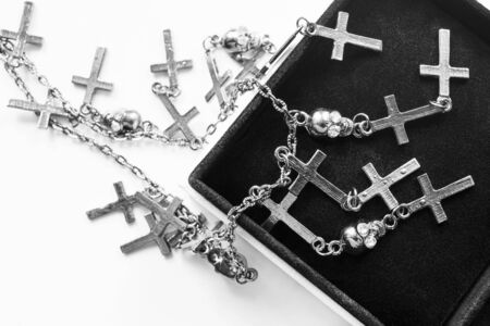 Silver chain with crosses and skulls in black jewel boxの写真素材