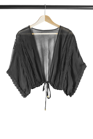 Black chiffon blouse on wooden clothes rack isolated over whiteの写真素材