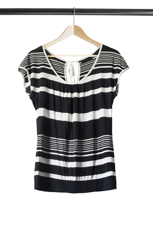 Black and white top on wooden clothes rack isolated over whiteの写真素材