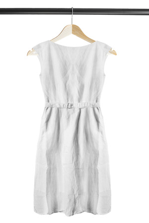 White linen dress on wooden clothes rack isolated over whiteの写真素材