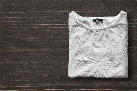 Folded white shirt on dark wooden backgroundの写真素材