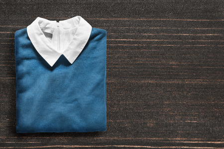 Folded blue pullover on dark wooden backgroundの写真素材