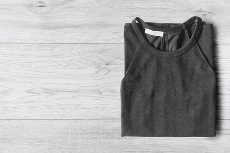 Black top folded on white wooden backgroundの写真素材