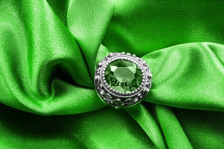 Vintage emerald ring on green satin as a backgroundの写真素材