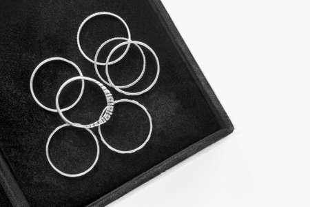 Group of silver rings in black jewel box closeupの写真素材