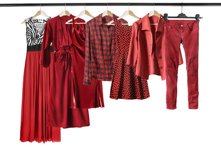 Group of red clothes on clothes racks isolated over whiteの写真素材
