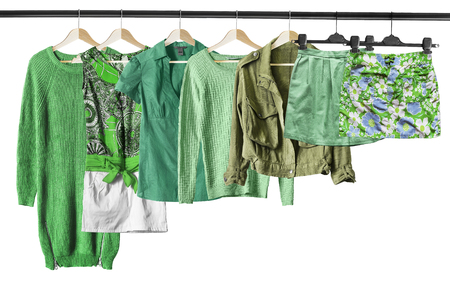 Set of green clothes on clothes racks isolated over whiteの写真素材